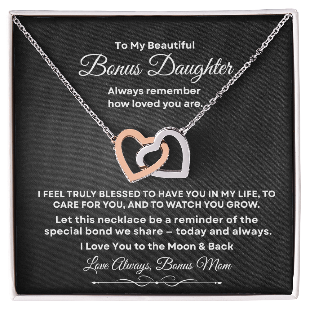 Interlocking hearts necklace in silver and rose gold resting inside a gift box on a message card for bonus daughter titled To My Beautiful Bonus Daughter from Bonus Mom.