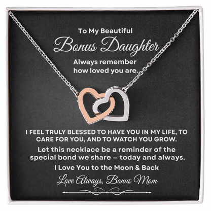 Interlocking hearts necklace in silver and rose gold resting inside a gift box on a message card for bonus daughter titled To My Beautiful Bonus Daughter from Bonus Mom.