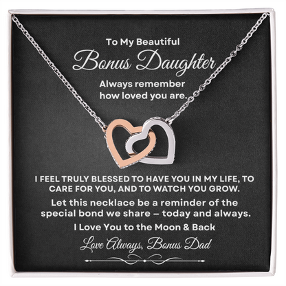 Interlocking hearts necklace in silver and rose gold resting inside a gift box on a message card for bonus daughter titled To My Beautiful Bonus Daughter from Bonus Dad.