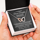 Hands holding an open black standard gift box displaying the interlocking hearts necklace and message card for bonus daughter.