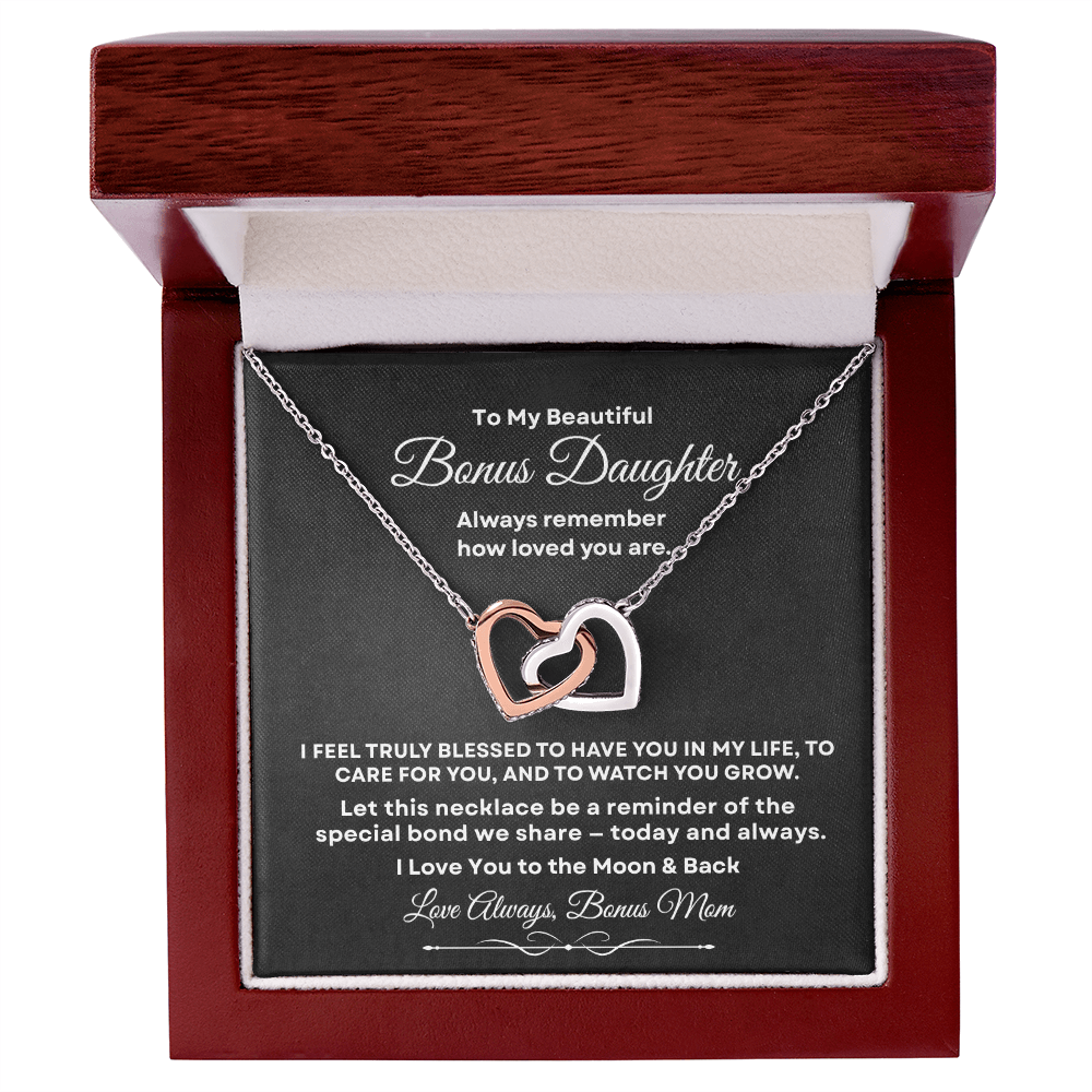 Interlocking hearts necklace in silver and rose gold resting inside a mahogany-style luxury gift box with built-in LED light on a message card for bonus daughter titled To My Beautiful Bonus Daughter from Bonus Mom.