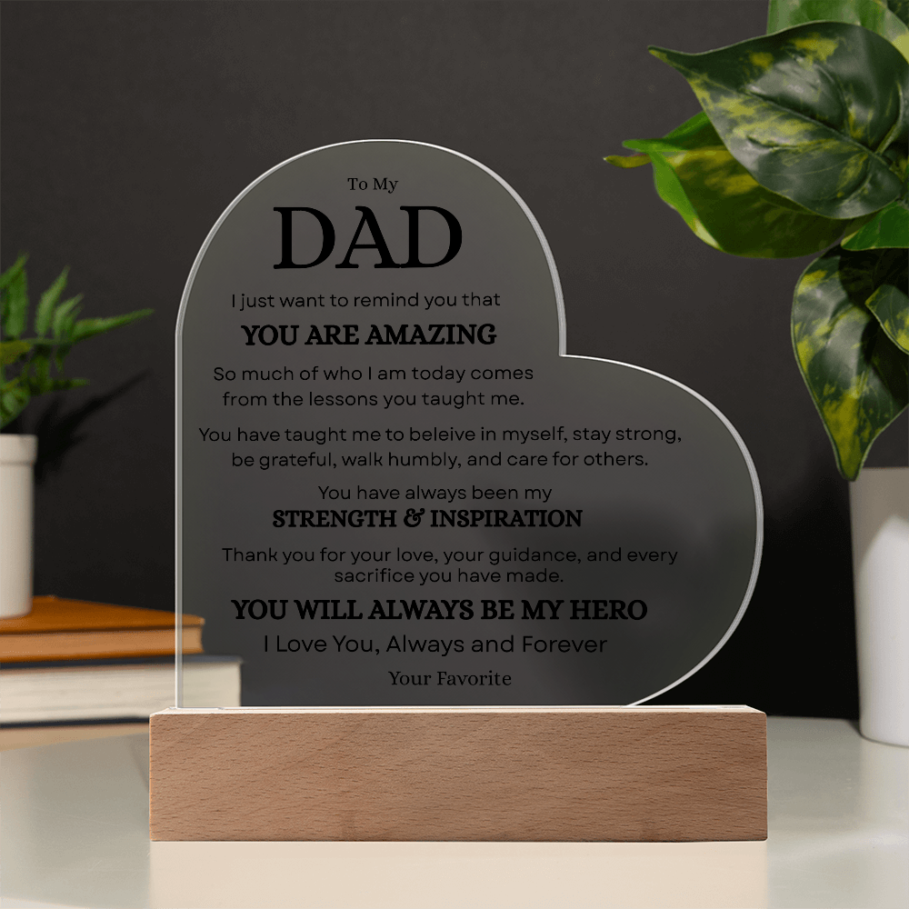 Dad acrylic plaque glowing on wooden LED base in a dark room setting