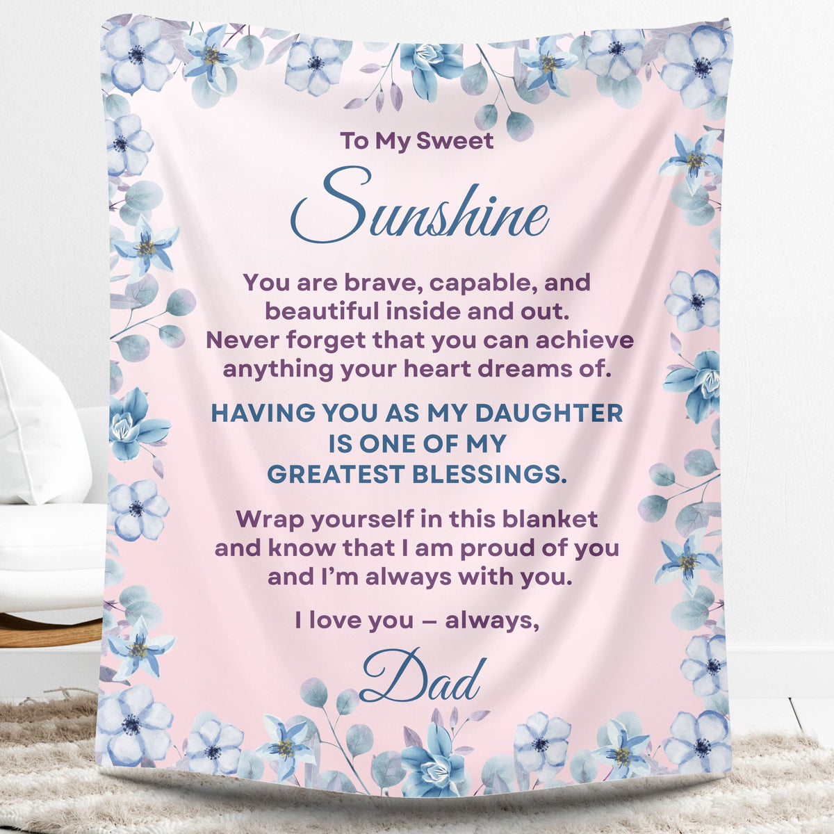 Personalized daughter blanket from Dad in Dusty Rose with a blue floral design, shown hanging in a cozy room setting. 