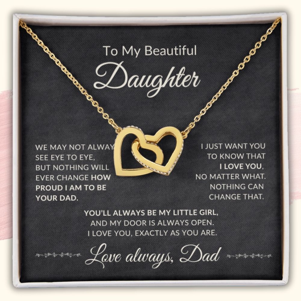 Gold interlocking hearts necklace with cubic zirconia crystals displayed inside an open gift box featuring a loving message card from Dad to his daughter.