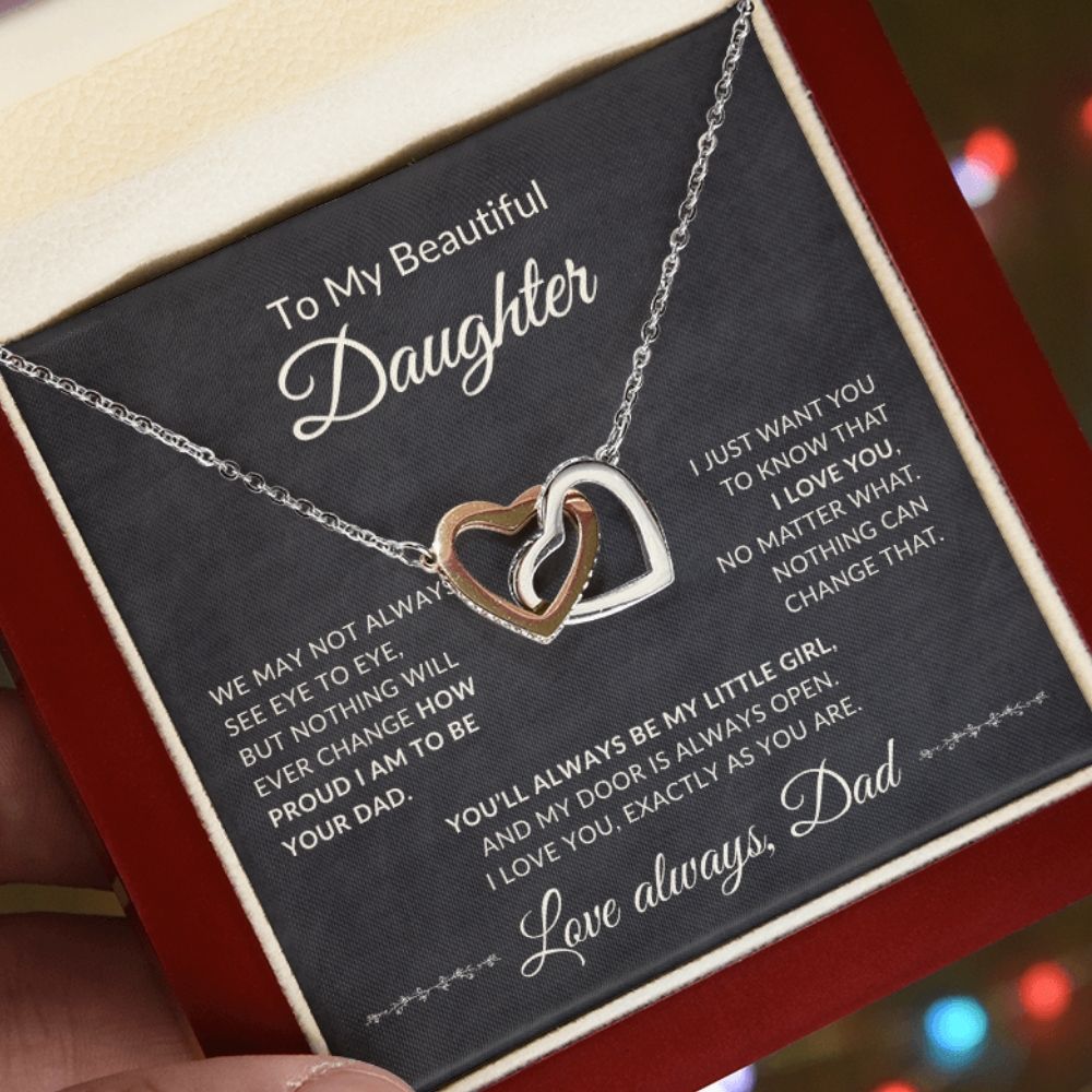 Interlocking Hearts Necklace for Daughter from Dad displayed inside a mahogany-style luxury gift box illuminated by an LED spotlight, highlighting the heartfelt message card.
