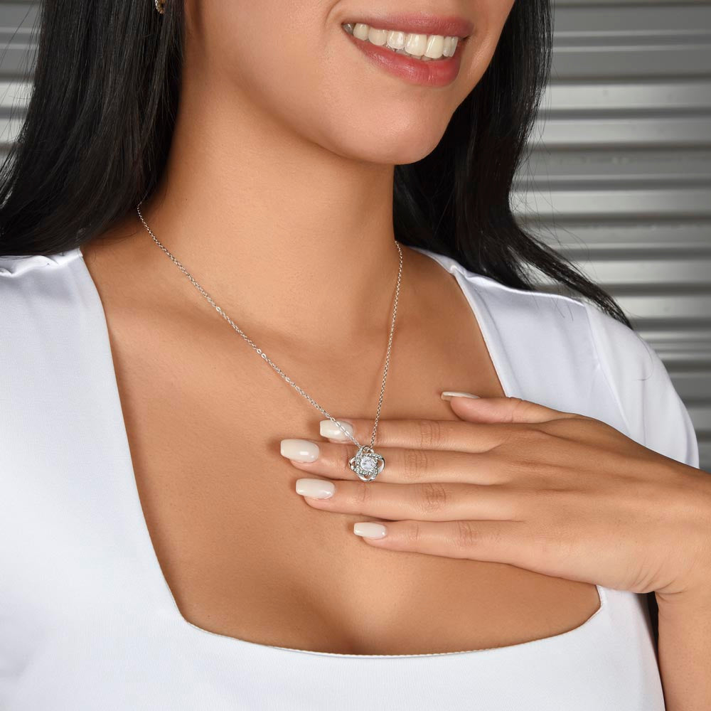 Mom wearing love knot necklace symbolizing the unbreakable bond between mother and son