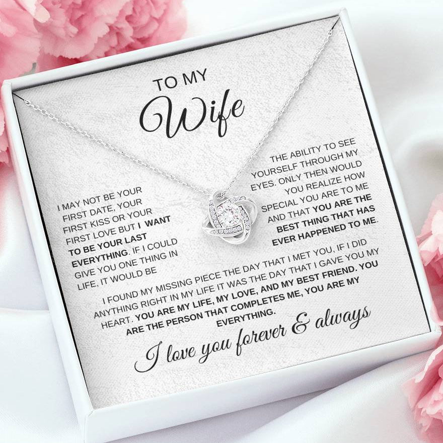 Necklace with a sentimental message card for a wife, surrounded by pink flowers.